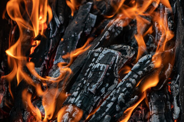 Glowing embers in hot red color, abstract background. The hot embers of burning wood log fire. Firewood burning on grill. Texture fire bonfire embers. - obrazy, fototapety, plakaty