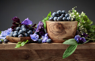 Summer still life with blueberries, colored sweet peas and meadow grasses.