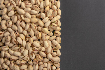 Roasted and salted pistachios in shell on dark background