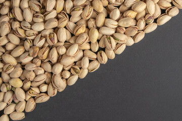 Roasted and salted pistachios in shell on dark background