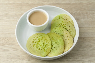 Serabi or Surabi,  Indonesian pancake made of flour, rice flour and coconut milk. Served with palm sugar sauce. Sweet and savory. Selective focus image.
