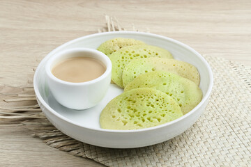 Serabi or Surabi,  Indonesian pancake made of flour, rice flour and coconut milk. Served with palm sugar sauce. Sweet and savory. Selective focus image.
