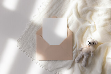 Invitation card in envelope with toy bear 
