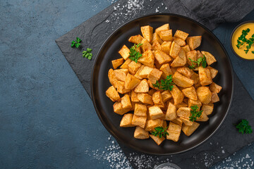 Patatas bravas with sauce on a graphite background with space to copy.