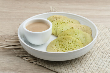 Serabi or Surabi,  Indonesian pancake made of flour, rice flour and coconut milk. Served with palm sugar sauce. Sweet and savory. Selective focus image.
