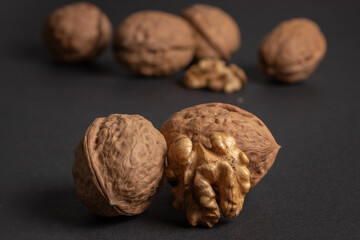Walnuts scattered on a dark background, macro