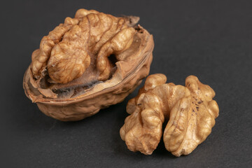 Walnuts scattered on a dark background, macro