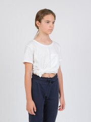 model samples , waist high portrait , white girl 11 years old in dark pants and a white shirt on a white