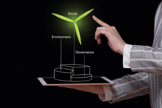 Environmental Social and corporate Governance ESG concept, a tablet in the hands of a businessman with a diagram and a wind turbine tower, green energy