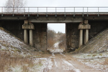 Fototapeta na wymiar road under a railway bridge, concrete bridge over a country road
