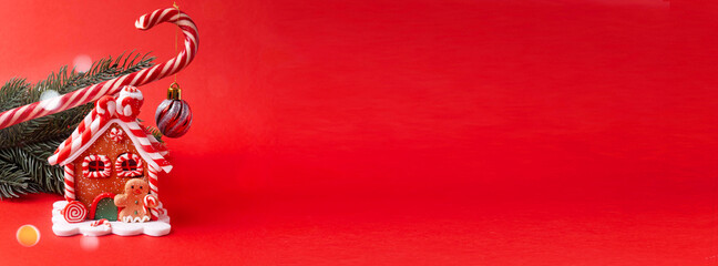 Gingerbread house, red clock, gift, lollipop, candy on a red background.
