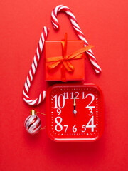 Toy, red watch, gift, lollipop, candy on a red background.