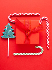 Toy, red watch, gift, lollipop, candy on a red background.