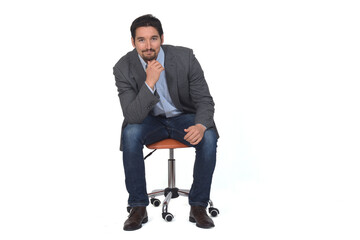 front view of a man with blazer sitting on chair, hand on chin  on white  background