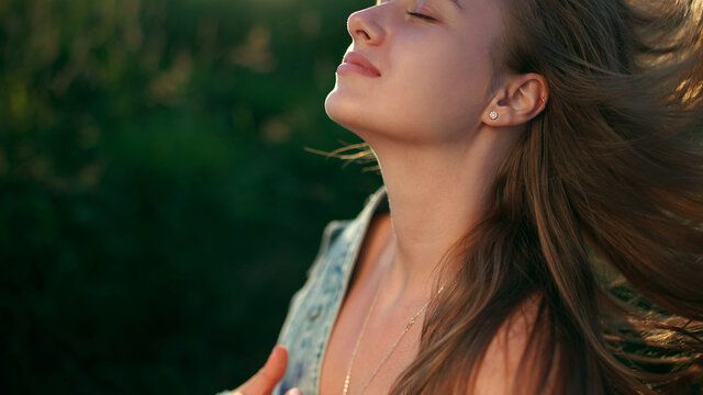 A blonde girl in black jeans with a denim jacket and "Bla bla bla" lettering holds her head up high. There are gold earrings in her ear and a helix piercing
