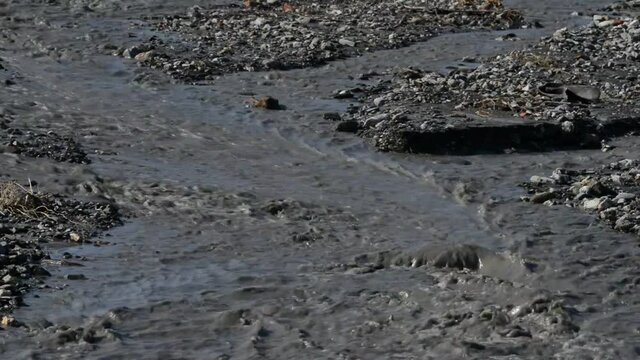 river of mud and water rushes towards the sea after intersting rains
