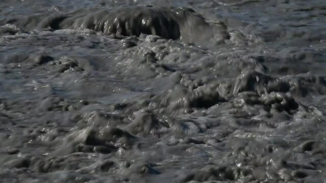 river of mud and water rushes towards the sea after intersting rains