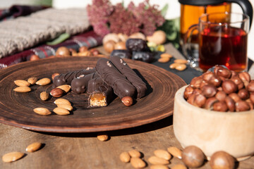 Tea time outside background and chocolate candy. Flowers and nuts. Copy space.