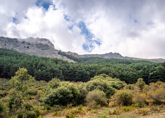 Fototapeta na wymiar cloudy landscape of a mountain and people hiking