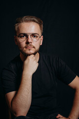 Charismatic attractive stylish guy with glasses leaned chin on hand and thought. Serious man ponders. Thinking person. Smart man with own opinion. Man develops idea. Young business man looks in camera