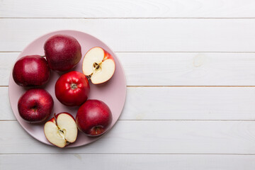 juicy red apples in a bowl or plate on the table top view. Copy space