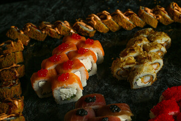 Traditional delicious fresh sushi roll set on a black background