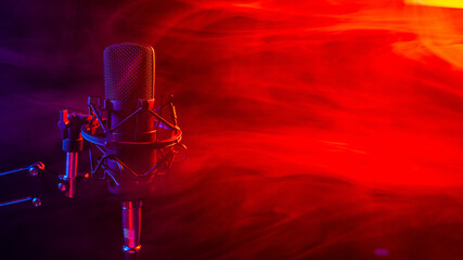 Professional microphone in red smoke on a black background.