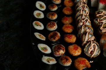 Traditional delicious fresh sushi roll set on a black background