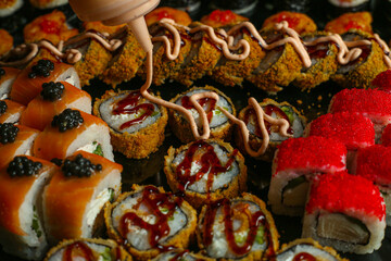 Fototapeta na wymiar Traditional delicious fresh sushi roll set on a black background