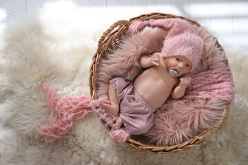 Adorable newborn baby with pacifier in wicker basket, top view
