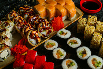 Traditional delicious fresh sushi roll set on a black background