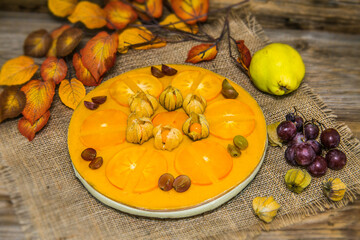 Light delicious yogurt cheesecake with physalis, orange and grapes . Close up