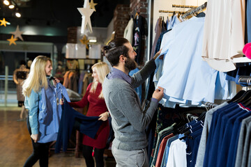 Man chooses a shirt in the store. Sale, shopping, fashion, style and people concept