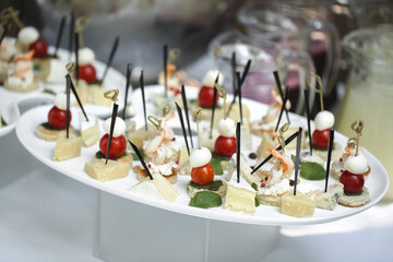 Catering table buffet dinner, beautifully decorated banquet with variety of different food snacks and appetizers on corporate birthday party event or wedding reception, canape, delicatessen setting