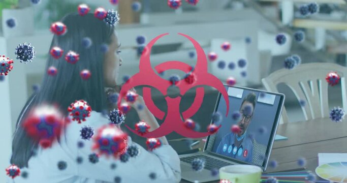 Animation of covid 19 cells over biohazard sign and businesswoman on laptop video call