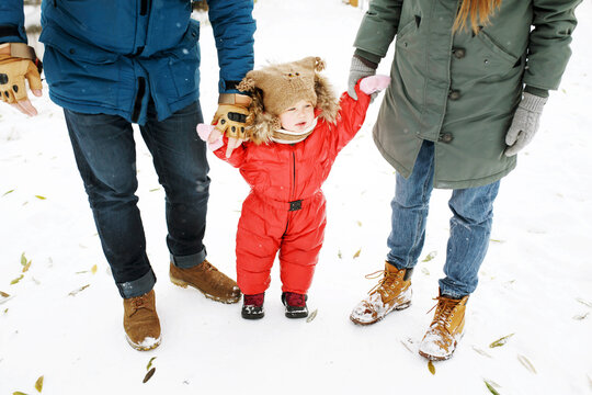 Unrecognizable Family With One Mischief Toddler In Winter Casual Outfit Walking Having Fun Outdoors