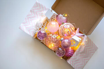 Preparing self care package. Seasonal gift box with Christmas balls and decorations for the holiday.