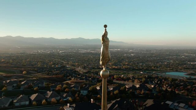 BEAUTIFUL SUNSET AND AERIAL CLOSE UP SHOT OF ANGEL MORONI ATOP LDS MORMON DRAPER UTAH TEMPLE,