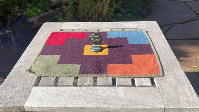 Chakana (Inca Cross) In The Middle Of A Handwoven Colorful Peruvian Textile (Pallay) On The Table Outdoor. zoom-in