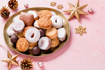 Holiday delicacies polvorones and mantecados in golden plate on pink table overhead