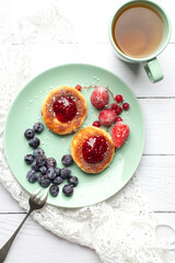 Cheesecakes with raspberry jam, berries, served with a cup of tea, cheesecakes

