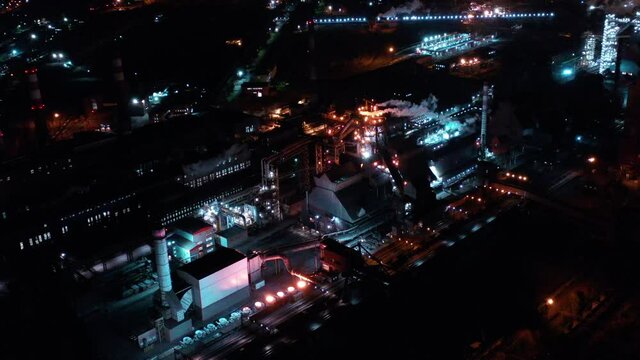 Night top view of the blast furnace of a metallurgical plant. Bright lanterns, smoke and smog of an industrial area