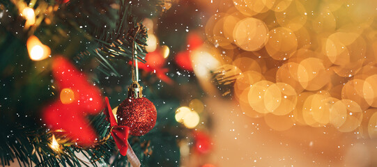 Artificial Christmas tree branch with red baubles and garland on shiny background © Anastassiya 