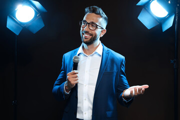 Motivational speaker with microphone performing on stage