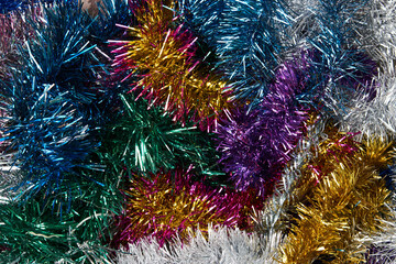Multicolored shiny tinsel background, top view