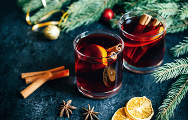 close-up on a hot alcoholic drink mulled wine in two transparent glasses with a cinnamon stick,...