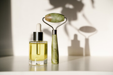 jade roller and face oil on white background © NadiaA