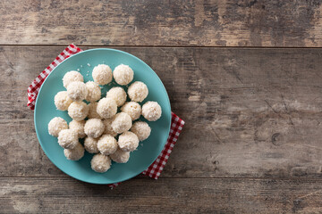 Homemade coconut balls on rustic wooden table. Copy space
