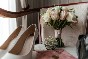 Wedding bouquet with wedding rings and shoes of the bride and groom