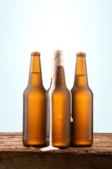 Cold beer bottle with water drops on a wooden table